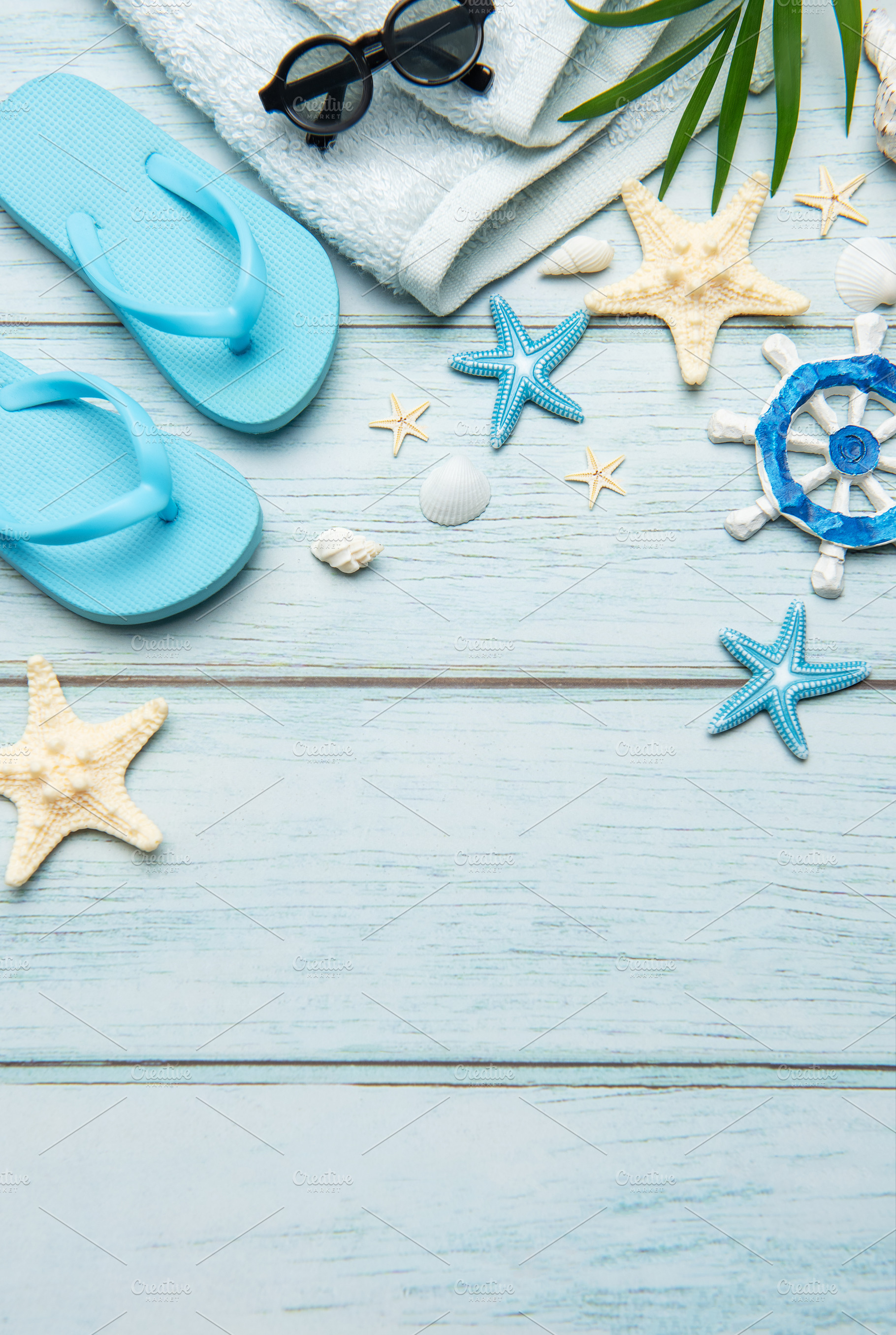 Summer accessories creating a frame on light blue wooden backgro, a Holiday Photo by Olena Rudo