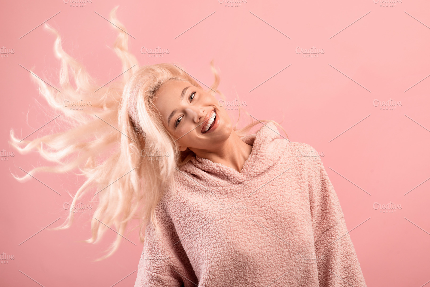 Happy blonde lady with shiny flying hair having fun and smiling at camera, posi, a Photo by Prostock-Studio