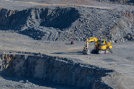 Yellow hydraulic excavator with crawler wheels in the mine with, an Industrial Photo by Joe McUbed