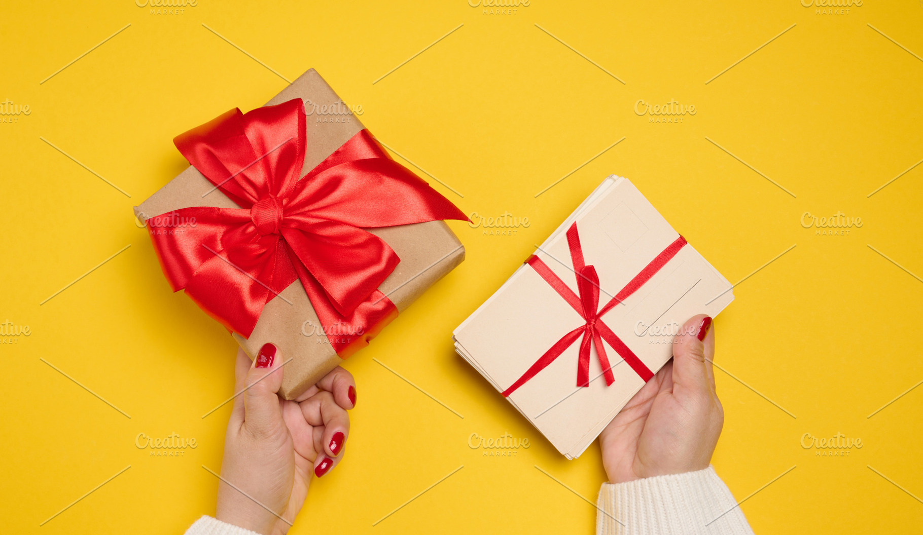 A woman's hands, one holding a gift box wrapped in craft paper w, a Holiday Photo by ndanko