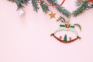 Horse christmas toy on pink flat lay with golden star, bauble an, a Holiday Photo by Sonjachni