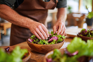Preparing a fresh seasonal salad with garden greens for a communal meal in a co, a Photo by AlyaAnd