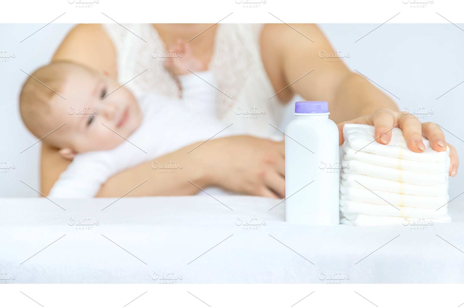 mother changes baby's diaper on a, a Person Photo by yanadjana