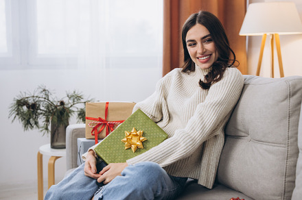 Beautiful happy woman unwrapping New Year or Christmas presents