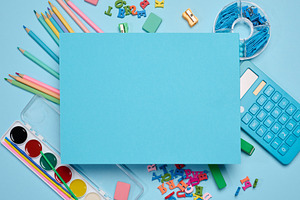 Bue sheet of paper in the center, surrounded by school supplies, a School & Education Photo by ndanko