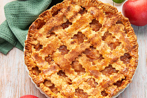 Freshly baked apple pie surrounded by ripe red apples and green, a Food & Drink Photo by Olena Rudo