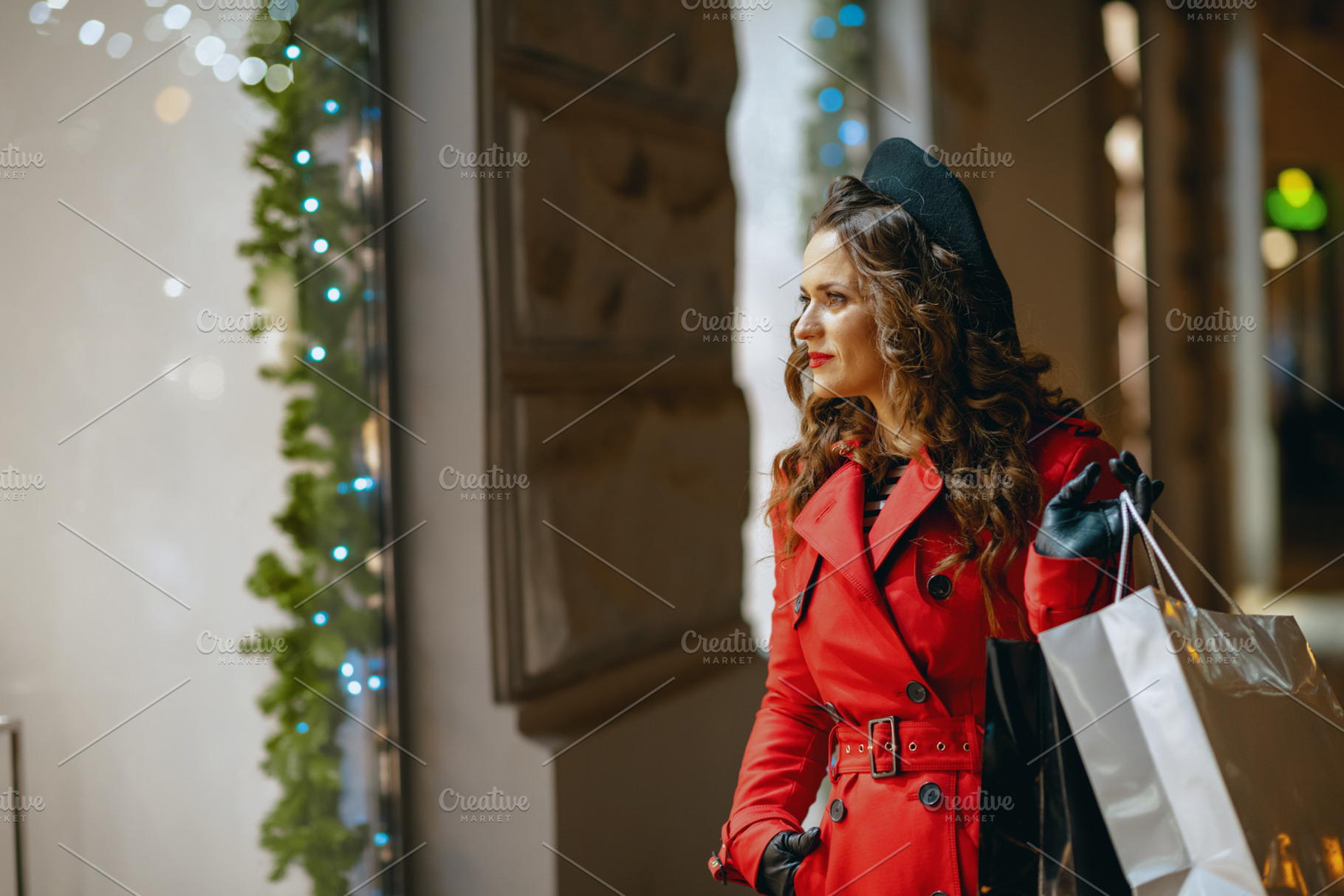 female shopper looking at shop window outdoors in city at night, a Person Photo by Alliance Images