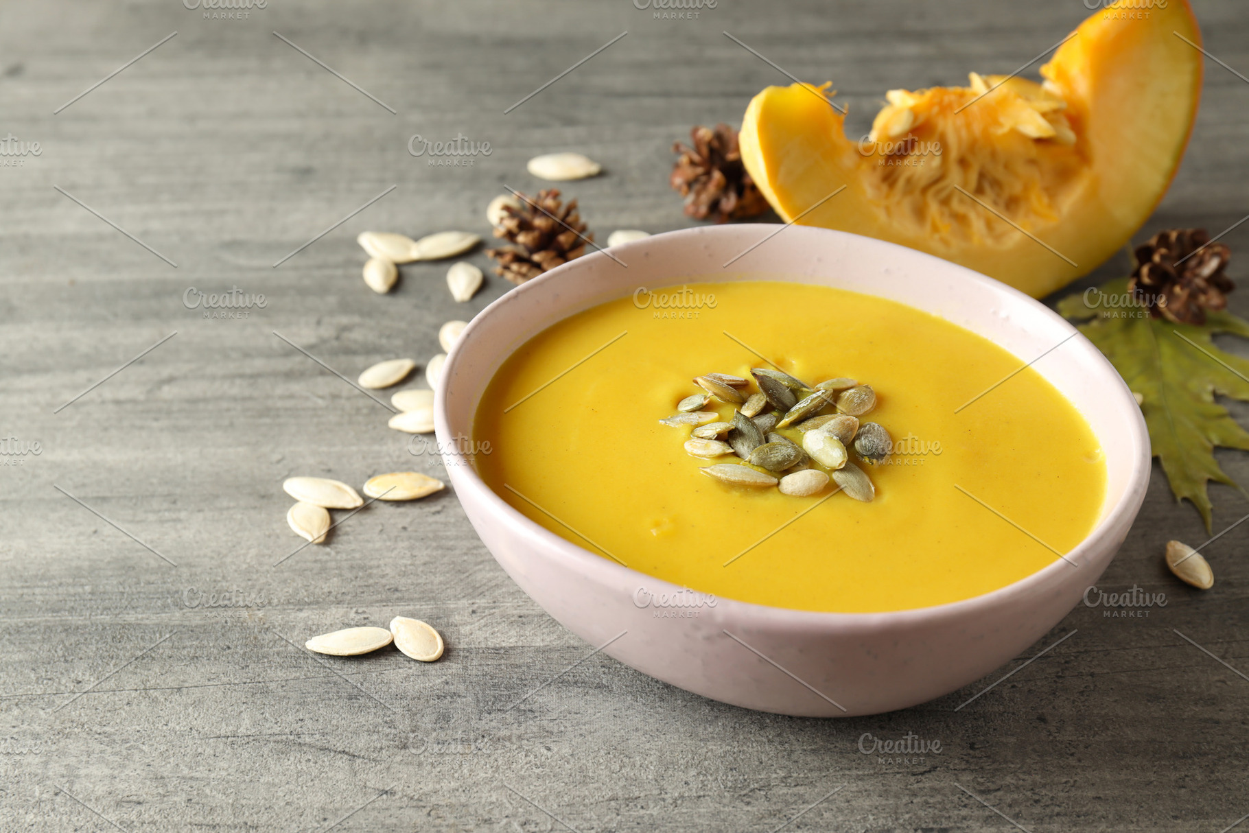Concept of tasty food with pumpkin soup on gray textured table, a Food & Drink Photo by AtlasStudio