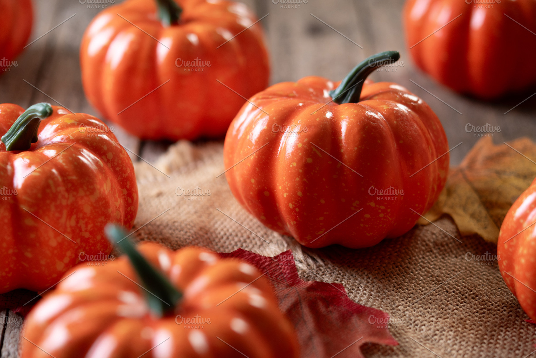 Mini decorative pumpkins on rustic wooden background with autumn leaves, a Food & Drink Photo by etorres69