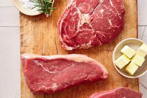 Raw rib-eye, roast beef, flank and rump steak on a wooden cutting board in a ki, a Food & Drink Photo by Asya Nurullina