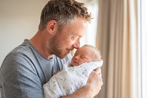 Father holding newborn baby in bright room, a Person Photo by AlyaAnd