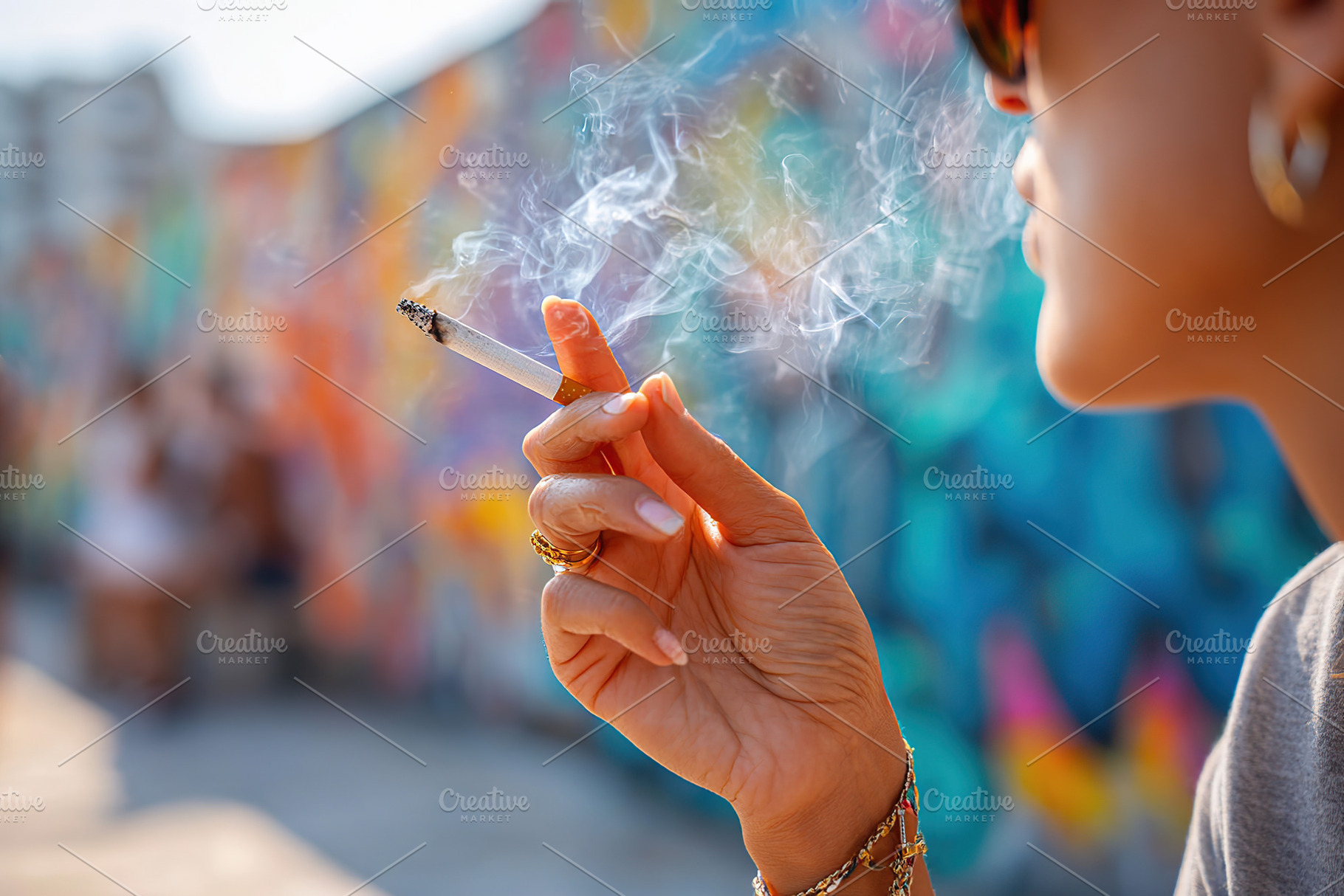 Woman enjoys a cigarette while relaxing near a vibrant mural in an urban settin, a Photo by AlyaAnd