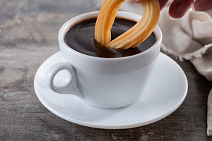 Hot thick chocolate in a white cup with churros, a Food & Drink Photo by etorres69