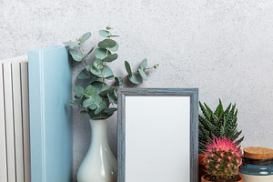Blue picture frame standing on wooden desk with plants and books, a Background Photo by Olena Rudo