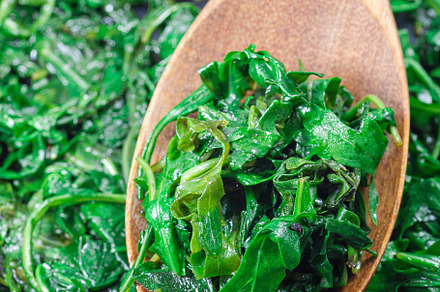 Wilted arugula or rocket salad, preparing a side dish to steak, in frying pan,, a Food & Drink Photo by iuliia_n