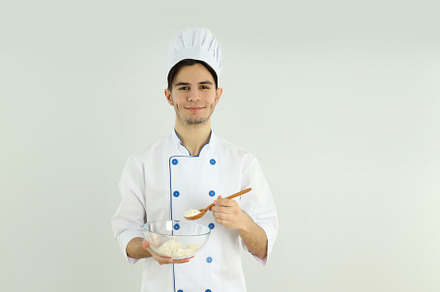 Concept of cooking, young man chef on light background, a Person Photo by AtlasStudio PRO