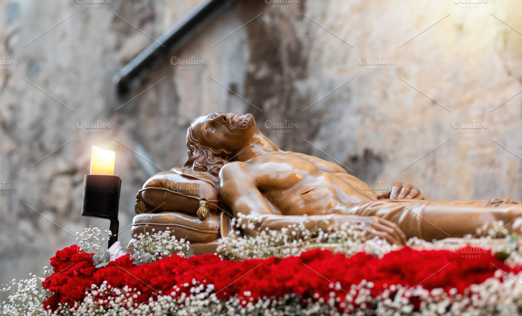 Wooden statue of Jesus Christ resting after crucifixion during Holy Week proces, a Holiday Photo by Antonio Gravante Market