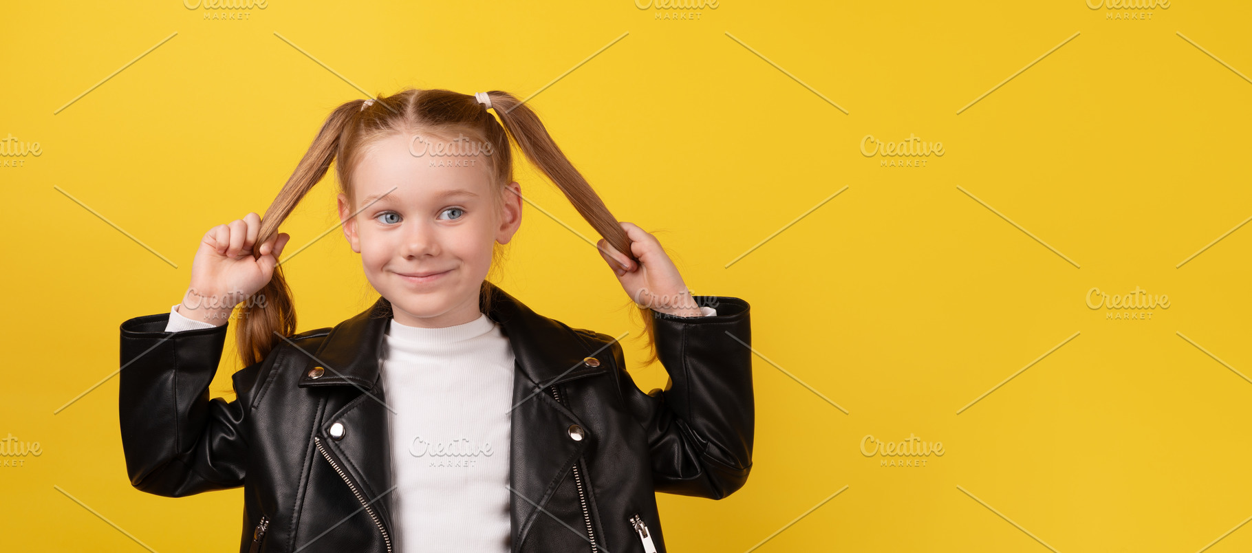 Smiling young girl in black leather jacket playfully holding her, a Person Photo by Ales Munt