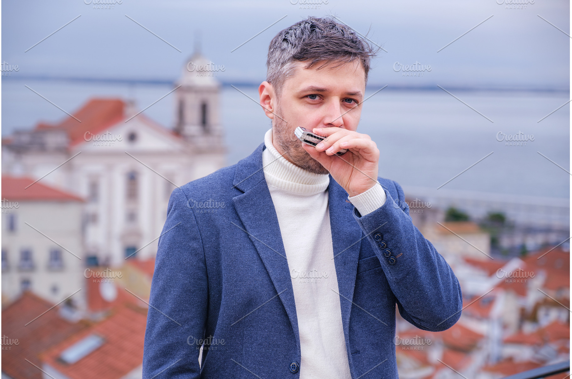 Man plays harmonica outdoors in city, a Person Photo by f9photos