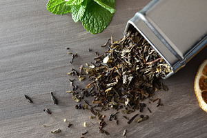 Wooden spoon filled with tea leaves on background of tea, a Food & Drink Photo by Davizro's Market