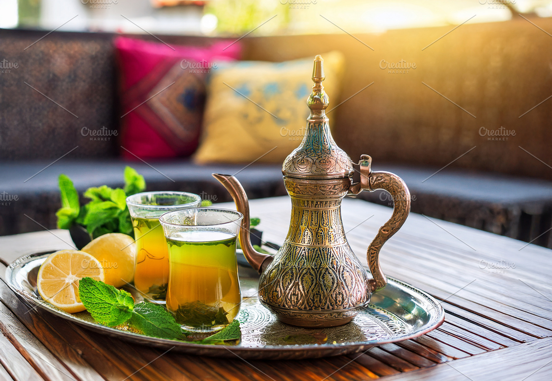Moroccan tea on wooden table on terrace with sofas, a Food & Drink Photo by Davizro's Market