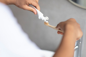 Daily dental care. Male hands pouring toothpaste on toothbrush, enjoying dental, a Person Photo by Prostock-Studio