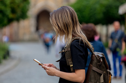 young girl with a smartphone on the background of the old church, a Person Photo by Masson Simon