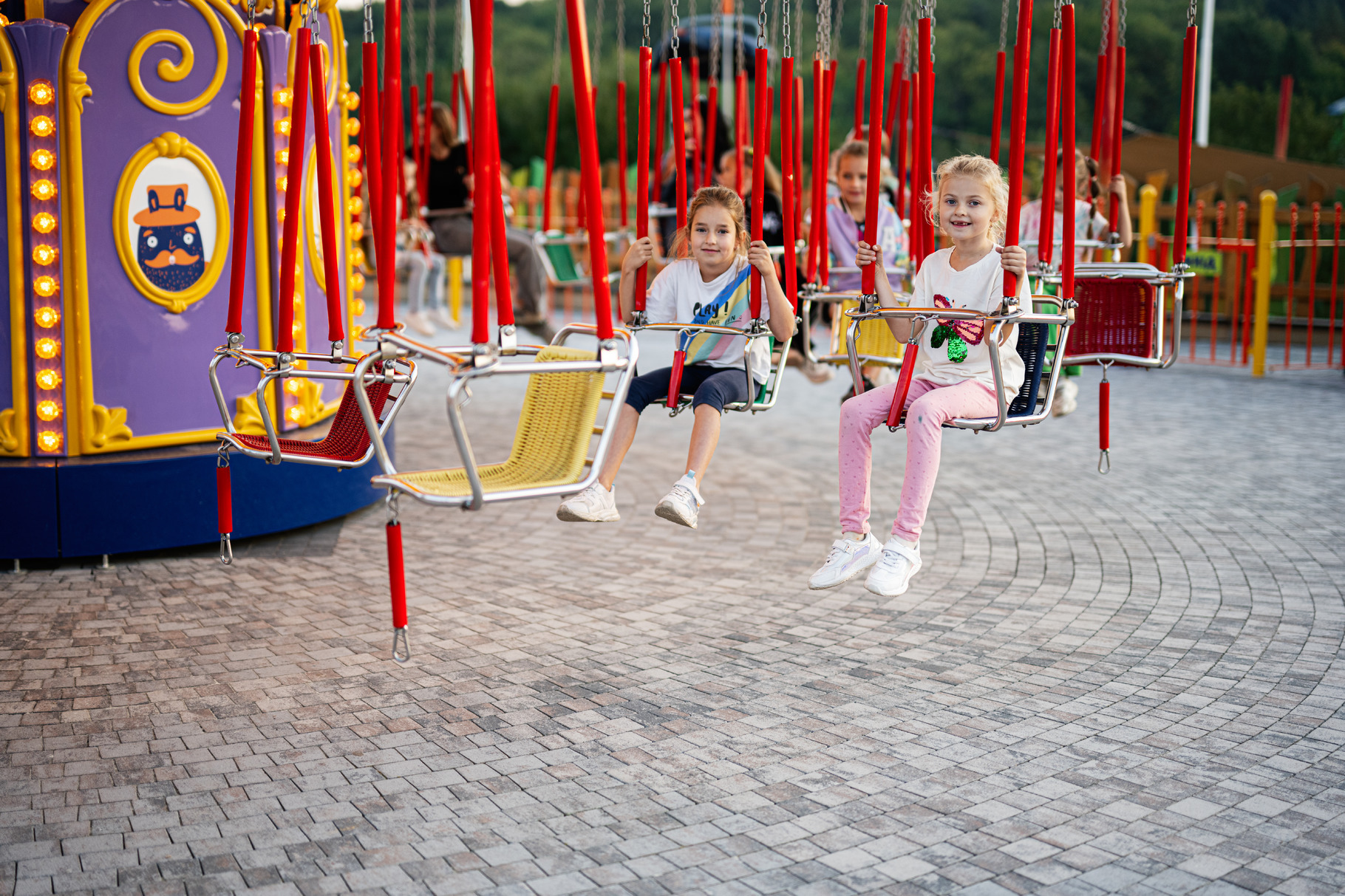 Children enjoying a carousel swing ride at the park, a Person Photo by ...