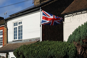 British flag, Union Jack, flapping on a flagpole attached to a h, a Photo by Studio ANNA