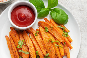 Sweet potato fries with ketchup and basil on plate, a Food & Drink Photo by Olena Rudo
