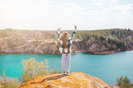 Young girl on the top of mounting and feeling free and looking at the blue lake, a Person Photo by travnikovstudio