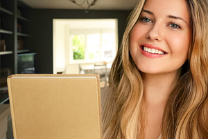 Happy young woman smiling, holding a book, enjoying home life an, a Person Photo by Studio ANNA