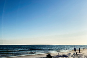Florida Pensacola beach scene with fishing rods on the sand and silhouettes wal, a Nature Photo by AS photostudio