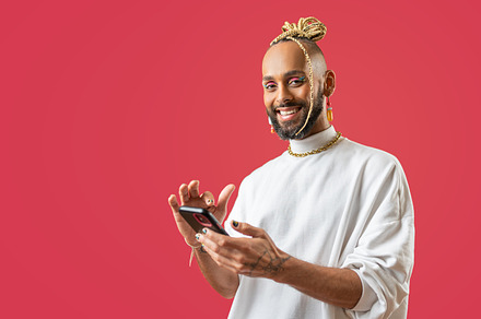 Black latin gay man with smartphone isolated on pink background, a Person Photo by andreonegin market