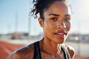 Athletic woman smiling on outdoor track, a Sports & Recreation Photo by AlyaAnd