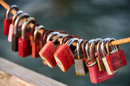 Love locks weathered on a chain on a bridge
