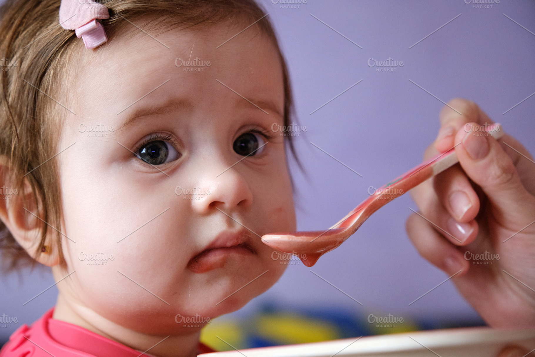 Close-up of a cute baby girl being fed with a spoon by a parent., a Person Photo by Rohan Photography