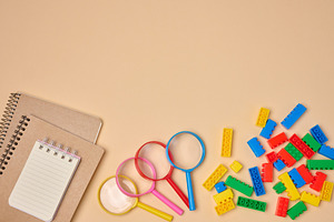 Flat lay of colorful plastic building blocks, magnifying glasses, a School & Education Photo by ndanko