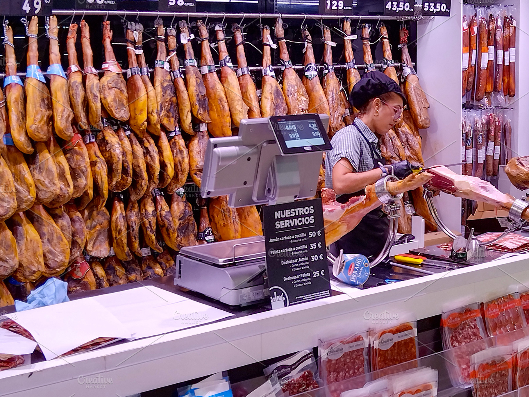 Charcuterie counter with hanging cured hams, a Food & Drink Photo by DanFLCreativo