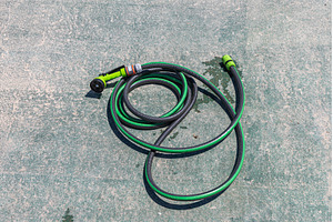 Green garden hose with spray nozzle, an Industrial Photo by Illustrations&photos