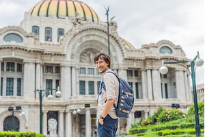 Male tourist standing in front of, an Architecture Photo by Elizaveta Galitskaya