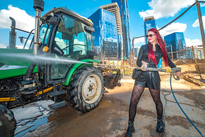 Red haired woman washing green tractor with high pressure cleane, a Photo by Pictures for you!!!!!!!!!