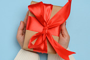 A woman's hands in a white knitted sweater hold a square gift bo, a Holiday Photo by ndanko (Thumbnail 2 of 3)