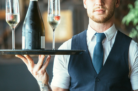 Cropped view of a waiter with glass