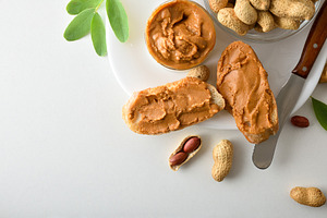 Bread with peanut butter isolated on white table, a Food & Drink Photo by Davizro's Market