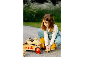 Girl carrying ducklings and baby, an Animal Photo by HalfPoint