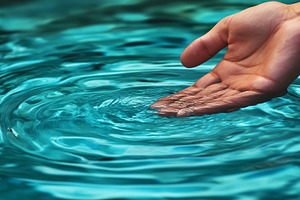 Hand gently touches turquoise water, a Nature Photo by MistyDay