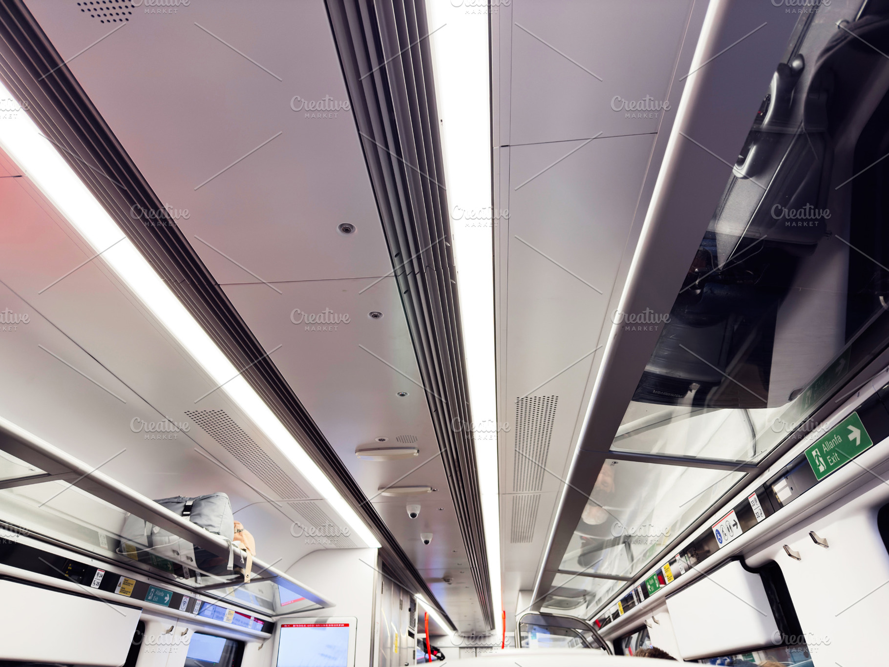 Interior of a modern train carriage with seating, luggage, and bright overhead, a Photo by AS photostudio