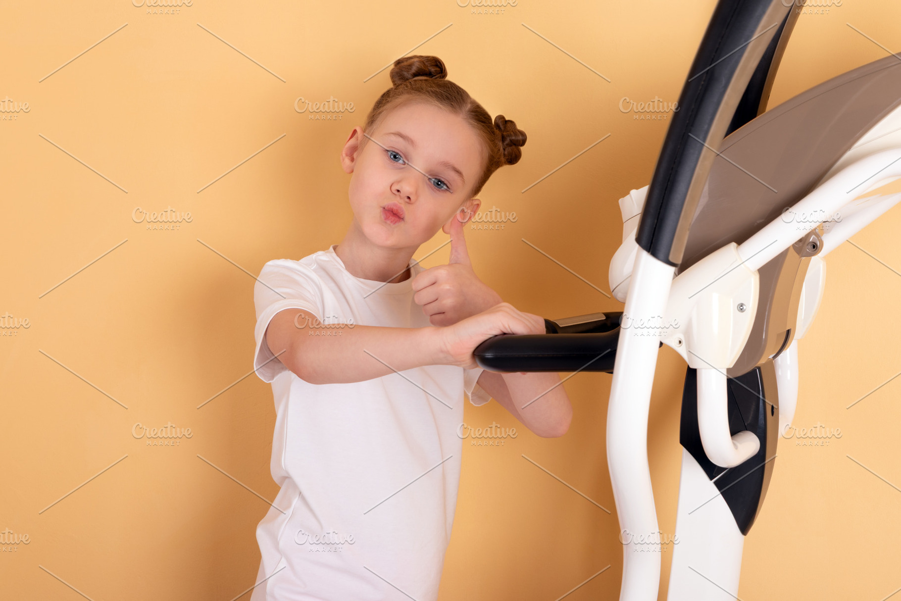 Smiling young girl in white t-shirt giving thumbs up while stand, a Person Photo by Ales Munt