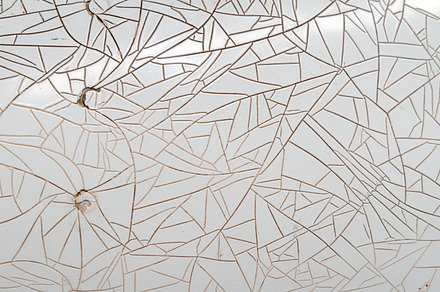 Cracked and peeling white plastic surface with intricate fractur